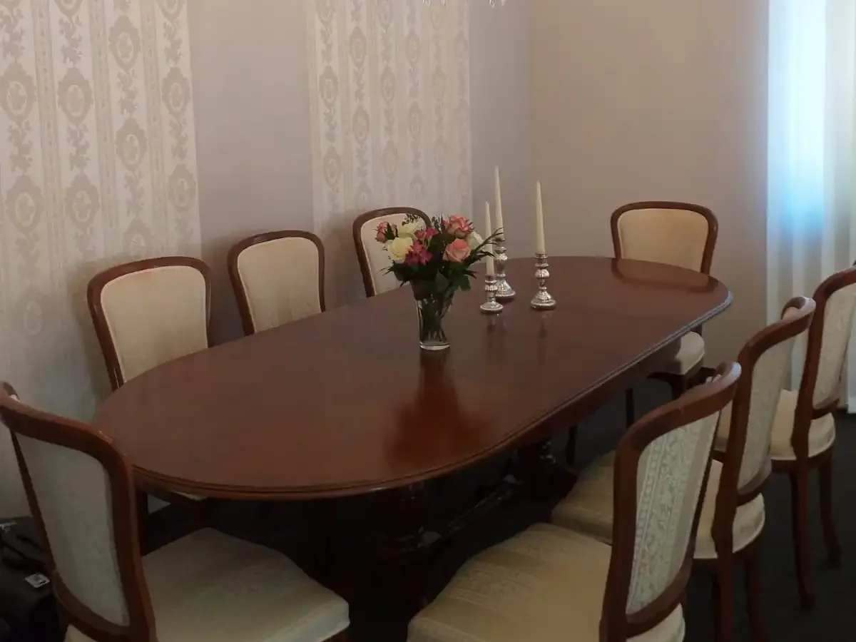 Verhandlungsraum der Firma Bestattungshaus an der Ilse, Tisch mit 8 Stühlen darüber ein Kronleuchter 